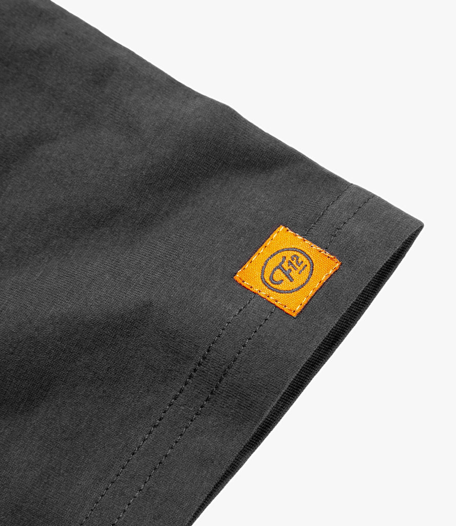 Closeup of woven F12 logo sewn on bottom of shirt.