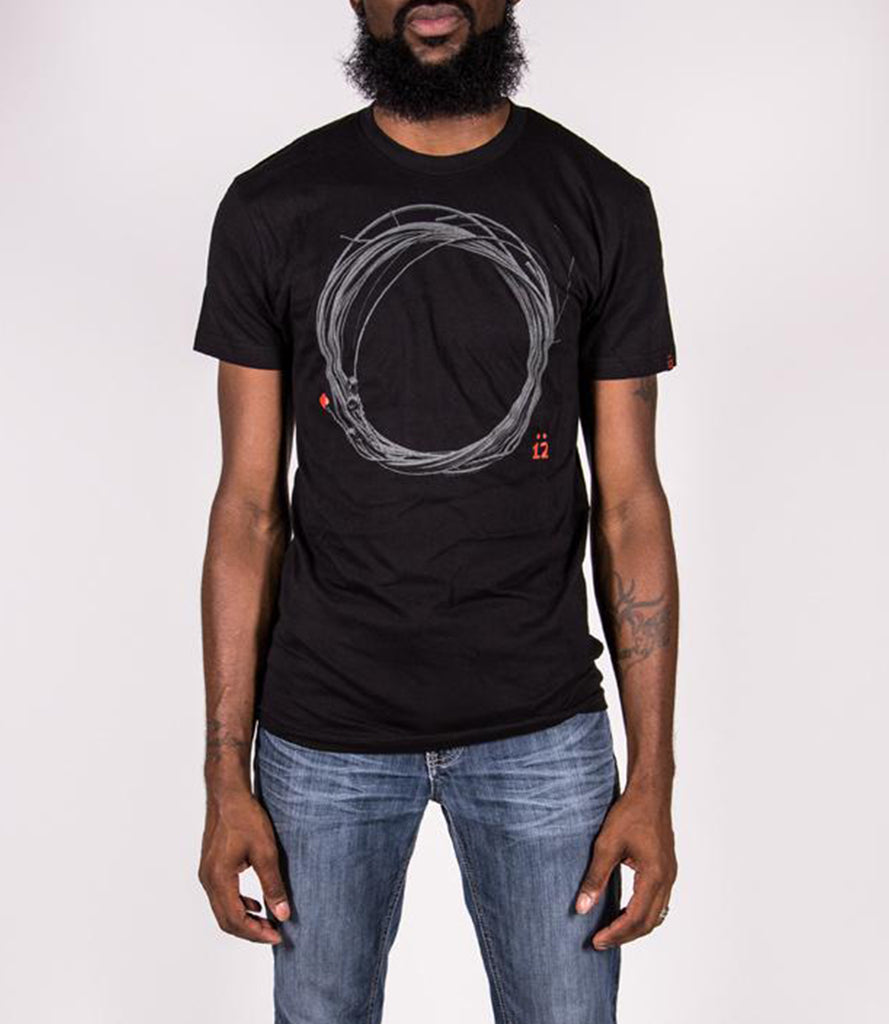 Model wearing black tee with O.G. Coil logo.