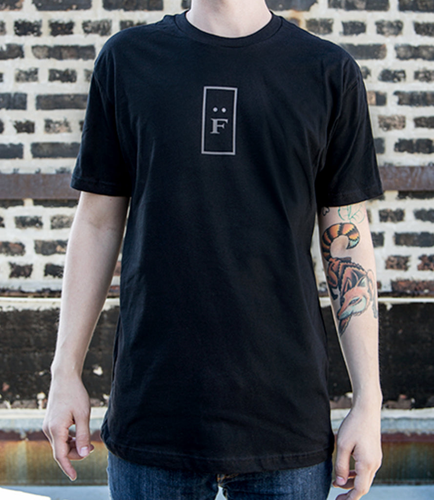 Model wearing black tee with "F" logo.